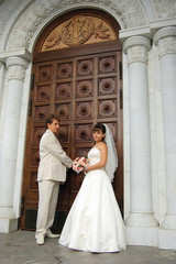 Bride with the groom near the entrance to the church