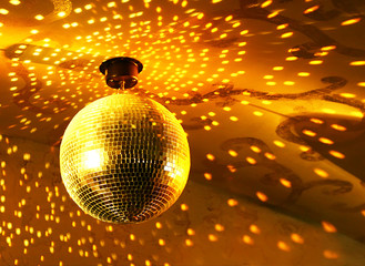 Shiny golden disco ball on nightclub
