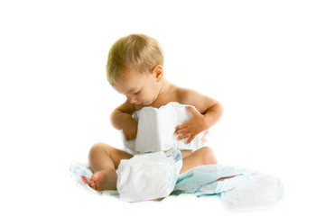 baby playing with diapers over white