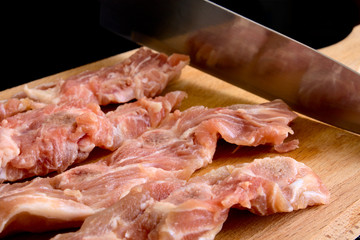 Meat pork on a chopping board with white layers and a knife
