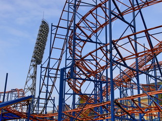Attraction a roller coaster, the big fixture and the blue sky.