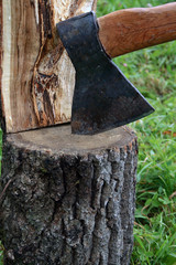 Close-up of axe in log with half of firewood