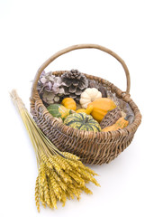 Wicker basket with autumn fruit and vegetables, isolated