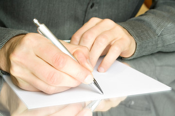 man writes a pen on an empty paper