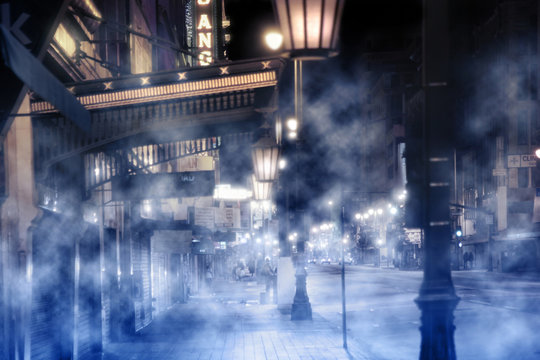 foggy street scene with lights and peolpe at night