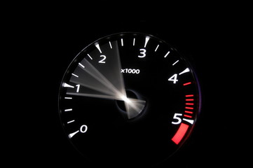 moving revs meter of a sports car on a black background.