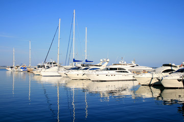 Parking of yachts against the azure sky is reflected in water