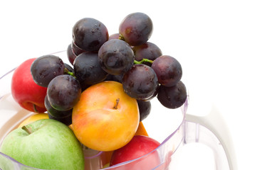 fresh fruits with juicing machine on white background.