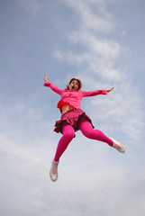 Plakat young girl dressed in pink colors to clothes in jump