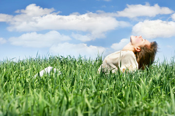 young girl relaxing in green grass