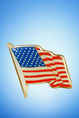 golden American Flag lapel pin on gradient background