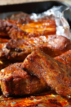 delicious spicy barbeque ribs in roasting tray on foil