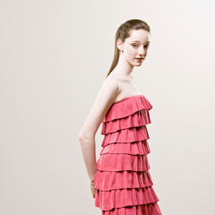 Studio shot of stylish young woman in frilly red dress