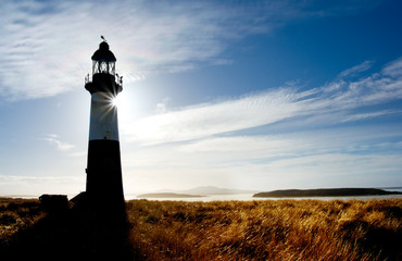 Lighthouse with sun glow behind, in the Falkland Islands