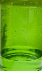 Green plastic bottle with water. A background, macro