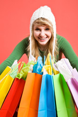 A happy beautiful caucasian girl holding shopping bags