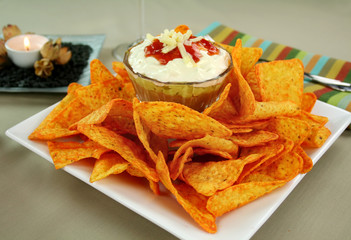 Nachos and Mexican dip topped with sour cream