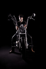 Fototapeta na wymiar Biker on chopper motorcycle in dark. Strong light from side