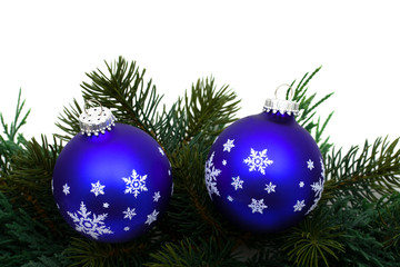 Christmas tree limb with blue glass ball ornaments on white