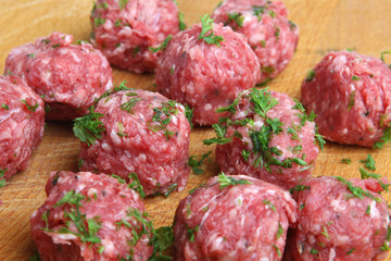 Beef meatballs being prepared on wooden chopping board