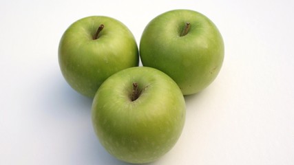 Three green apples on white background