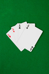 Four aces on green poker table.