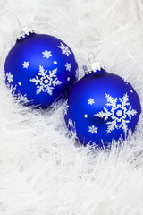 Blue glass ball on white shiny garland making a background