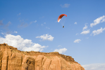 a powered paraglider pilot in flight over Monument Valley