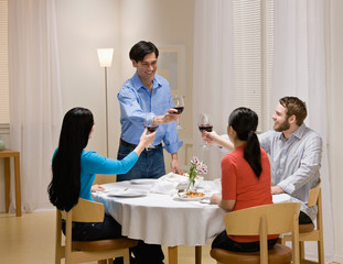 Couple toasting with red wine at elegant dinner party