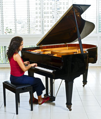 women pianist playing on a grand piano