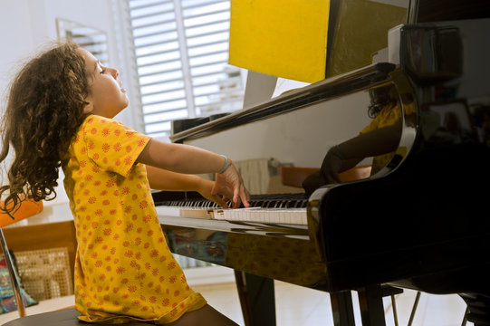 little girl playing the grand piano