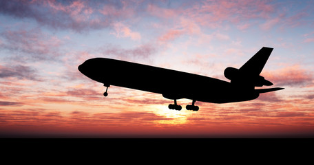 Silhouette of airplane over sunset - obrazy, fototapety, plakaty