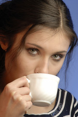 young woman with  cup in  hand looks,  close up