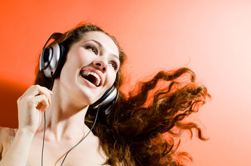 girl in headphones on the orange background