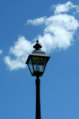 A Black lamp post against blue sky