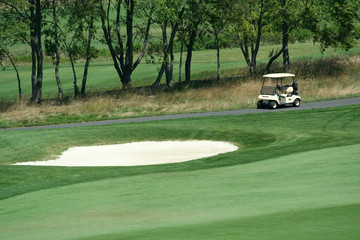 A Golf cart parked near a sand trap