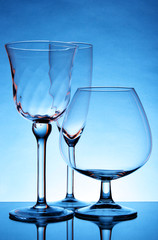 Still-life with empty glasses over blue background