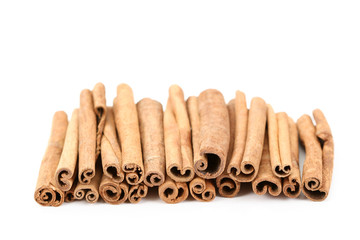 heap of cinnamon sticks isolated on white