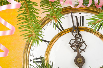 New Year's decoration with an antique clock and a firtree branch