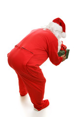 Santa Claus in footy pajamas, bending over to pick up gift