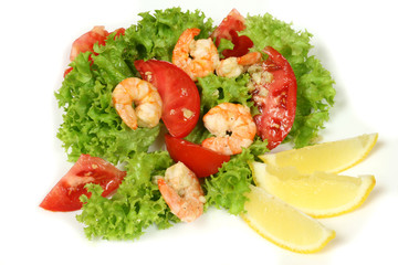 Shrimp salad with lettuce, red tomatoes and lemons
