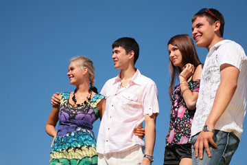 Two happy couples on sky background