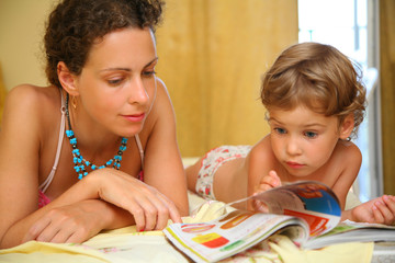 Obraz na płótnie Canvas Mother and child read magazine