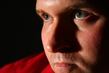 Obraz premium Thinking man in red shirt in dark