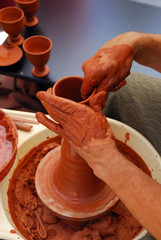 View of the hands of a potter working on a cup