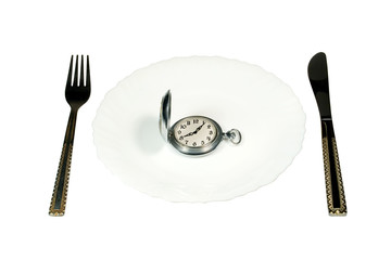 Pocket watch on a white plate (“eating up time” concept)