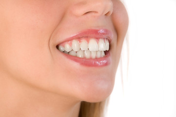 Closeup of beautiful smile of young woman. Isolated over white