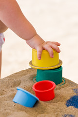 Children's hand and toys on sand