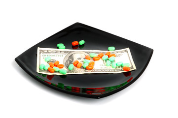 Obraz na płótnie Canvas expensive chemical diet - pills on black plate and dollars