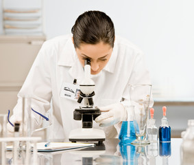 Research scientist in lab coat looking at specimen in laboratory